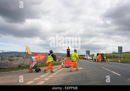 Baustellen und Arbeiter auf einer Landstraße mit Stop Lichter, England, UK Stockfoto