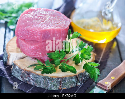 rohes Fleisch und Petersilie auf dem Tisch Stockfoto