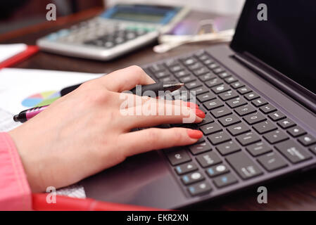 weibliche Hand zählt Budget auf laptop Stockfoto