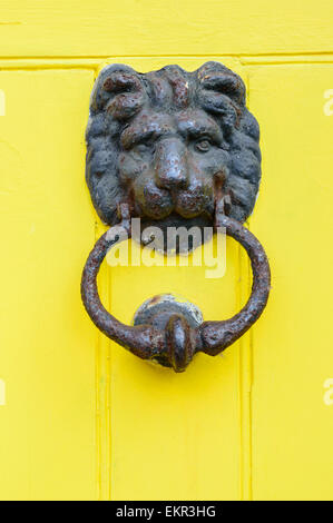 NOTTINGHAM, ENGLAND - APRIL 12: A Löwen Kopf Türklopfer an leuchtend gelbe Tür. Am 12. April 2015, in Nottingham, England. Stockfoto