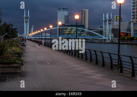 Salford Quays in der Nacht mit Lichter beleuchten den Fußweg entlang der Kanalseite Stockfoto