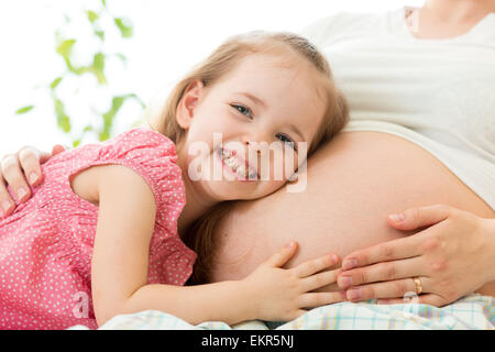 glückliches Kind Mädchen umarmt schwangere Mutter Stockfoto