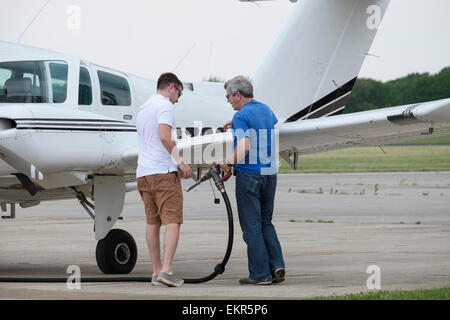 Piloten Bereiten kleiner zwei zweimotorigen Flugzeuge mit Flugbenzin Schlauch und Düse zu tanken Stockfoto