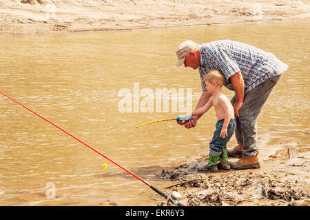 Großvater, Enkel, Fische mit Spielzeug Rute und Rolle Lehre Stockfoto