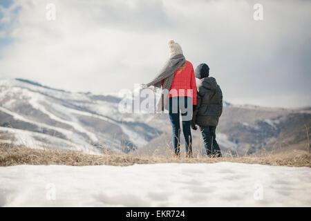 Bruder und Schwester nebeneinander stehen im Schnee, Rückansicht. Stockfoto