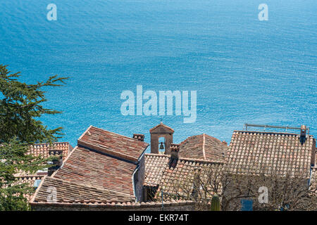 Blick auf das azurblaue Mittelmeer Meer über die Terrakotta-Dächer von Eze Village an einem sonnigen Tag Stockfoto