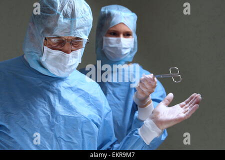 Ein Assistang gibt Arzt Schere in einem op Stockfoto