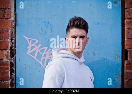 Junger Mann in einer ungepflegten Umgebung trägt ein t-Shirt oder Hoodie Stockfoto