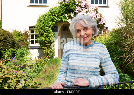 Ältere Frau stehen außen hübschen Cottage Stockfoto