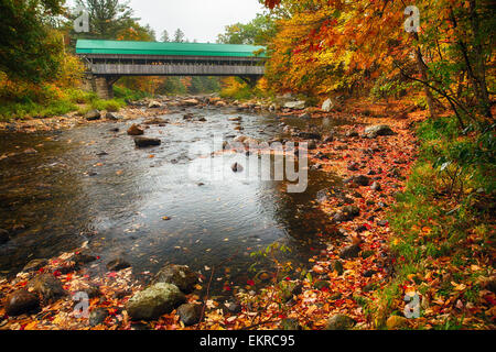 Niedrigen Winkel Blick auf eine überdachte Brücke mit Herbstlaub, Jackson, Carrol County, New Hampshire Stockfoto