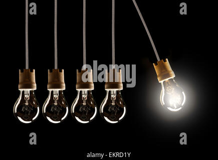 Glühlampen in Reihe mit Single in Bewegung und shinning, auf schwarzem Hintergrund isoliert Stockfoto
