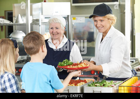 Schülerinnen und Schüler bei Schule Cafeteria serviert Mittagessen Abendessen Damen Stockfoto