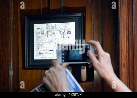 Montevideo, Uruguay. 13. April 2015. Ein Tourist nimmt ein Bild eines Zeichentrickfilms der uruguayische Schriftsteller Eduardo Galeano, in der Cafe-Brasilero, die er verwendet, in der Ciudad Vieja in Montevideo, Hauptstadt von Uruguay, am 13. April 2015 zu besuchen. Uruguayischer Schriftsteller Eduardo Galeano, Autor der "offenen Adern Lateinamerikas", starb am Montag in Montevideo im Alter von 74 Jahren. © Nicolas Celaya/Xinhua/Alamy Live-Nachrichten Stockfoto