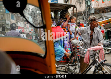 Rikscha und seine Passagiere in Varanasi, Uttar Pradesh, Indien. Stockfoto