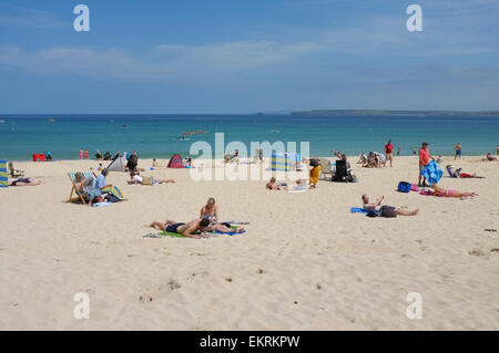 Menschen, die zum Sonnenbaden am Porthminster Strand von St Ives in Cornwall Stockfoto