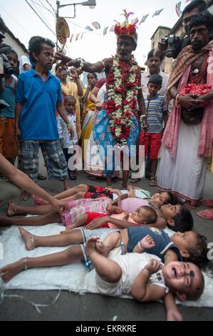 Kolkata. 14. April 2015. Indisch-hinduistischen Kinder liegen auf der Straße als Teil des Rituals während des Shiva Gajan Festivals in Kalkutta, Hauptstadt des östlichen indischen Bundesstaat Westbengalen, 13. April 2015. Gläubigen Hindu Anhänger angeboten verschiedene Rituale und symbolische Opfer hoffen die Gunst des Gottes Shiva und markiert die Ankunft des neuen Jahres für Bengali Kalender. Bildnachweis: Tumpa Mondal/Xinhua/Alamy Live-Nachrichten Stockfoto