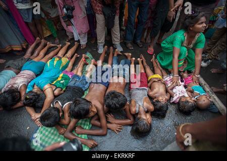 Kolkata. 14. April 2015. Indisch-hinduistischen Kinder liegen auf der Straße als Teil des Rituals während des Shiva Gajan Festivals in Kalkutta, Hauptstadt des östlichen indischen Bundesstaat Westbengalen, 13. April 2015. Gläubigen Hindu Anhänger angeboten verschiedene Rituale und symbolische Opfer hoffen die Gunst des Gottes Shiva und markiert die Ankunft des neuen Jahres für Bengali Kalender. Bildnachweis: Tumpa Mondal/Xinhua/Alamy Live-Nachrichten Stockfoto