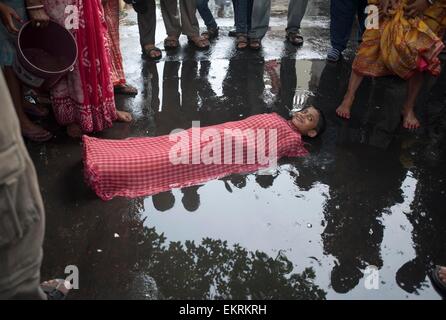 Kolkata. 14. April 2015. Ein indisch-hinduistischen Kind liegt auf der Straße als Teil des Rituals während des Shiva Gajan Festivals in Kalkutta, Hauptstadt des östlichen indischen Bundesstaat Westbengalen, 13. April 2015. Gläubigen Hindu Anhänger angeboten verschiedene Rituale und symbolische Opfer hoffen die Gunst des Gottes Shiva und markiert die Ankunft des neuen Jahres für Bengali Kalender. Bildnachweis: Tumpa Mondal/Xinhua/Alamy Live-Nachrichten Stockfoto