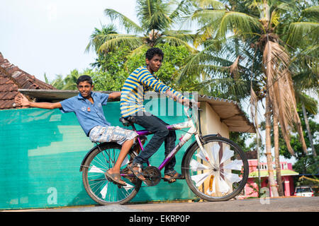 Zwei jungen auf einem Fahrrad an den Ufern der Backwaters Kumarakom, Kerala Indien Stockfoto