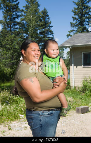 Native American Mutter und ihr Sohn stehen außen vor einem Haus. Stockfoto