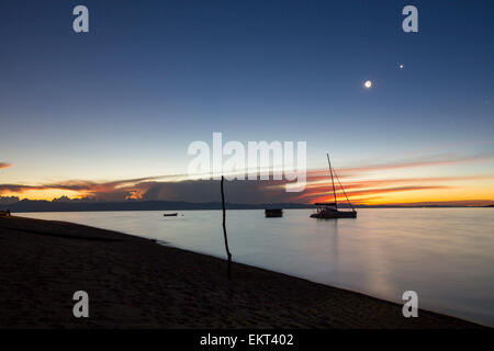 Sonnenuntergang am Cape Maclear am Ufer des Lake Malawi Blick auf Berge auf dem jenseitigen Ufer mit einem Mond, Planeten und Sternen, Stockfoto