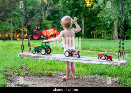 junge winken für Papa auf Traktor Stockfoto