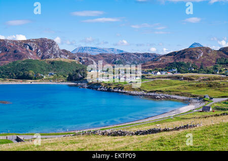 Scourie Bay bei Flut, Campingplatz am Wasser und Dorf auf der rechten Seite, Arkle und Ben-Stack in der Ferne sichtbar. Stockfoto