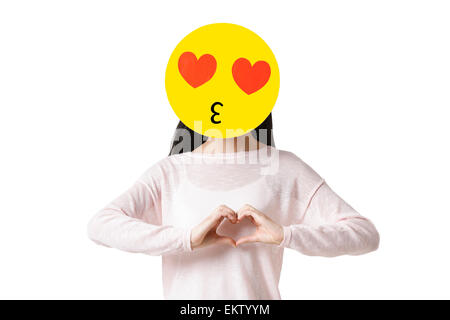 Junge Frau mit einem romantischen Emoticon Gesicht vor ihr Gesicht Stockfoto