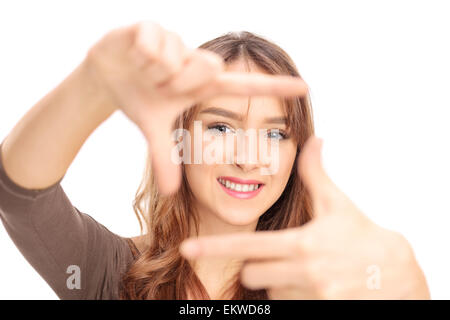 Schöne Brünette Mädchen umrahmen ein Foto mit den Fingern mit dem Fokus auf ihrem Gesicht isoliert auf weißem Hintergrund Stockfoto