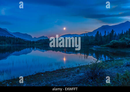 2. Juli 2014 - zunehmende Mondsichel über nahen See in Bow Valley Provincial Park, Alberta, Kanada, östlich von Banff und Canmo Stockfoto