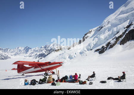 Gruppe von Besuchern warten auf Ski Flugzeug aufgreifen, die Ruth-Gletscher in Alaska Range, Sommer. Stockfoto