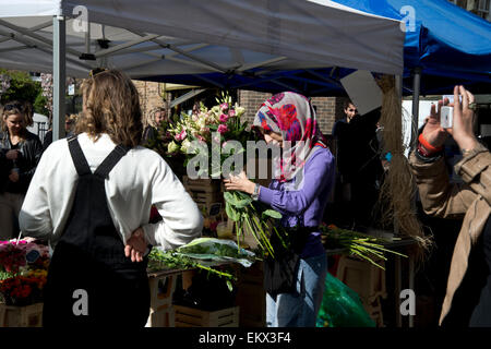 Hackney Frühjahr 2015. Broadway-Markt. Blume-Stall - Sträuße, mit jemandem aufnehmen eines Fotos auf einem Handy machen Stockfoto