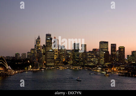 Abendlicher Blick auf den Hafen von Sydney von Kirribilli aus mit der Sydney Harbour Bridge und dem Circular Quay, beleuchtet bei Dämmerung. Stadtlichter, die im Wasser reflektiert werden Stockfoto