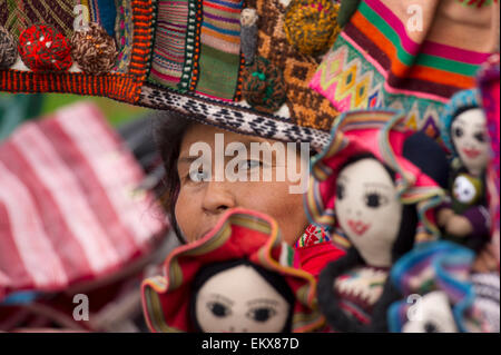 Eine Frau Peers von hinten Stoff neben Puppen auf dem Display hängen; Cusco-Peru Stockfoto