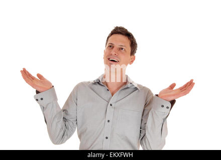 Ein junger Mann stehend isoliert für weißen Hintergrund mit seiner Hands hob in einem grauen Hemd. Stockfoto