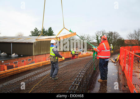 Bauarbeiter mit Guide Seil am Kran Lift auf der Baustelle. Stockfoto