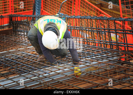 Bauarbeiter Betonstahl vor dem Gießen des Betons auf einem Geschäftshaus Dach zu binden. Stockfoto