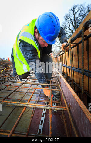 Bauarbeiter Betonstahl vor dem Gießen des Betons auf einem Geschäftshaus Dach zu binden. Stockfoto