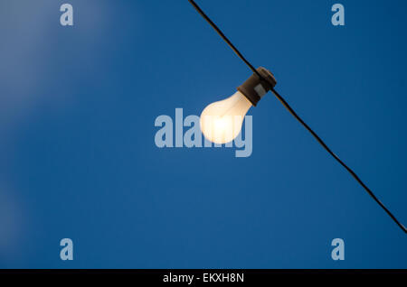 Elektrische Glühbirne vor einem tiefblauen Himmel. Stockfoto