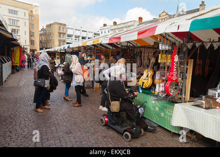 Ein behinderter Mann auf einem Mobilität Roller einkaufen in Cambridge Market, Cambridgeshire England UK Stockfoto