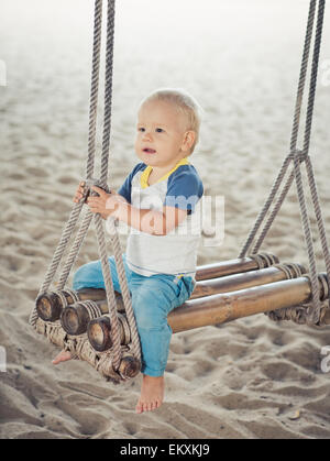 Baby-sitting auf einer Bambus-Schaukel Stockfoto