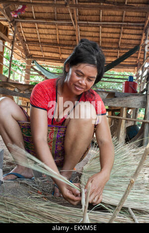 Kambodschanische Frau weben Palmwedel auf einem Hausdach in Kep, Kambodscha machen. Stockfoto