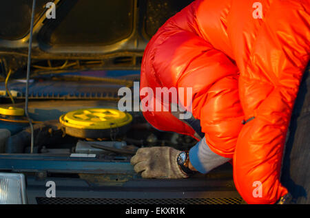 Treiber-Check-Auto-Motor unter der offenen Haube, Ratgeber in rote Jacke Stockfoto