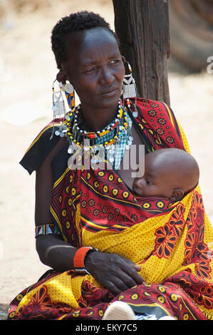 Samburu Stammes Frau hält ihr Baby in ihrer Nähe mit bunten Stoff Schlinge; Samburu National Reserve, Kenia Stockfoto