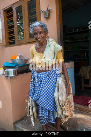 Eine ältere indische Frau vor ihrem Haus in Kumarakom, Kerala Indien Stockfoto