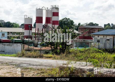 Eine alte verfallene suchen aber arbeiten Fabrik mit roten und weißen Schornsteine und Palmen in einem abgelegenen Teil von Kuba Stockfoto