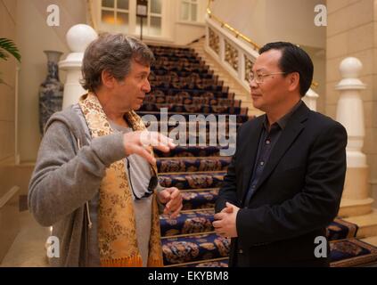 Peking, China. 14. April 2015. Jury von der 5. Beijing International Film Festival Robert Mark Kamen (L) Gespräche mit einem Mitarbeiter des Organisationskomitees, nach seiner in Peking, Hauptstadt von China, 14. April 2015 Ankunft. Bildnachweis: Chen Junqing/Xinhua/Alamy Live-Nachrichten Stockfoto