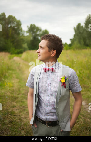 Porträt von gut aussehenden jungen Mann elegant gekleidet. Boutonniere. Rote Schleife. Stilvolle person Stockfoto