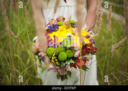 Hochzeitsblumen. Close-up. schöne junge Braut mit Brautstrauß in Händen. Frau mit Blumen hautnah. vertikale Foto. Stockfoto