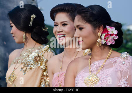 Eine Thai Braut und ihre Brautjungfern genießen eine Hochzeitszeremonie in Thailand. Braut zeigt schöne Zähne und Klammern. Stockfoto